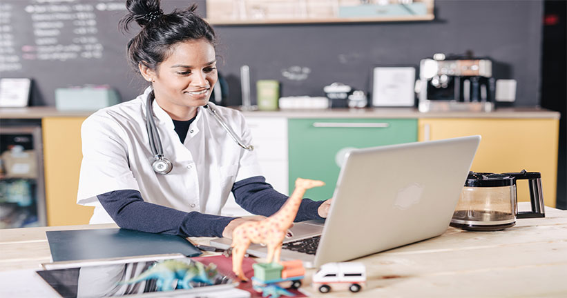 woman on laptop in medical uniform 